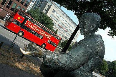 011_14604 - Skulptur des Hamburger Originals an der Ludwig- Erhardt- Strasse; ein Bus der  Stadtrundfahrt Hamburg fhrt vorbei.