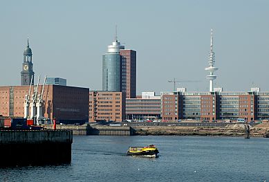 011_14650 - eine Barkasse der Hafenrundfahrt berquert die Elbe; links der Kaispeicher A, dahinter der Kirchturm von der St. Michaeliskirche - re. davon der Turm des Hansatic Trade Centers HTC am Kehrwieder und am Elbufer das Areal der Hafencity am Sandtorhafen./ Grasbrookhafen. 