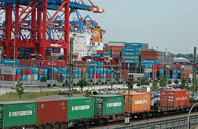 011_14363 - im Vordergrund transportiert ein Gterzug die Container aus dem Hafengebiet; im Hintergrund sind entladene Container gelagert - ein Frachtschiff liegt am Kai.