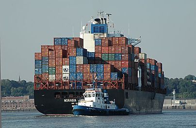 011_14861 - ein hochbeladenes Containerschiff verlsst den Hamburgre Hafen; es wird von einem Schlepper in die Fahrrinne der Elbe bugsiert. 
