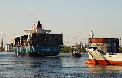 011_15591 - das Heck eines Containerfrachters mit einem Schlepper sowie der Bug eines Feeders.