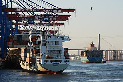 011_15595 - der Containerzubringer legt am Ballinkai an; im Hintergrund verlsst das Schiff den Hamburger Hafen.