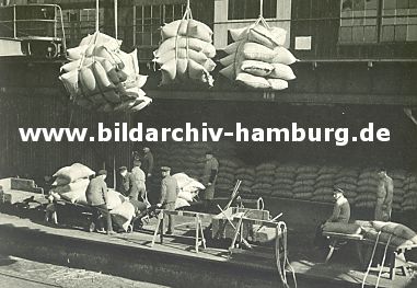 011_15816 - Kaffeescke werden im Hamburger Hafen an Land gebracht - Hafenarbeiter transportieren die Ladung mit Sackkarren; im Hintergrund sind die Scke im Lagerhaus gestapelt.  ( ca. 1939 ).