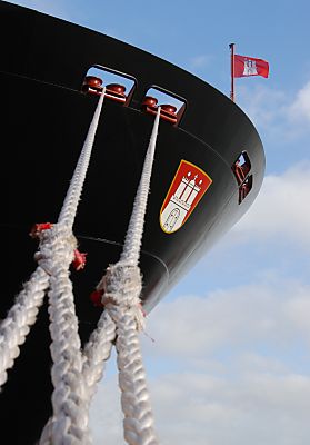 011_15820 - Seil und Schiffsbug des Containerschiffs "Hanover"; ber dem Hamburg Wappen flattert die Hamburg Fahne im Wind. 