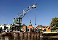 083_8073 Hafenkai von Stadt, ein Rollkran steht am Hafenrand; im Hintergrund Wohnh�user und ehemalige Speichergeb�ude. Rechts das Heck mit der Ruderanlage des 1902 in Itzehoe gebauten und jetzt restaurierten K�stenfrachters "DORA VON STADE".