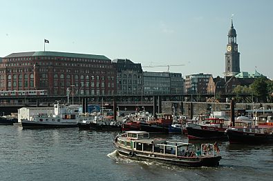 011_14885 - eine Barkasse der Hafenrundfahrt passiert den Liegeplatz der Flussschifferkirche; lks. das Slomannhaus, re. das Hamburger Wahrzeichen, der Michel.