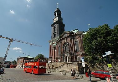 011_14585  ein roter Doppeldeckerbus einer Hamburger Stadtrundfahrt an der Rckseite der St. Michaelis-Kirche. 