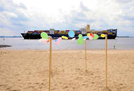 8672 Sandstrand bei Hamburg Blankenese - bunte Luftballons; Reste eines Kinderfestes; auf der Elbe fhrt ein Containerfrachter Richtung Hamburger Hafen.
