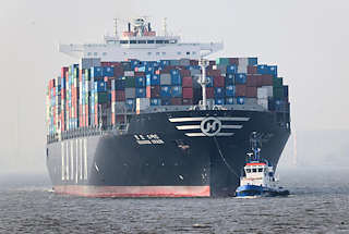 1621 Der Containerfrachter HANJIN SPAIN fhrt mit Schlepperhilfe in den Hamburger Hafen ein - hoch beladenes Containerschiff vor Hamburg.