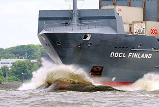 8929 Schiffsbug Wulstbug mit hoher Gischt - Containerschiff in voller Fahrt auf der Elbe - OOCL Finland, Wellen und Wasser.