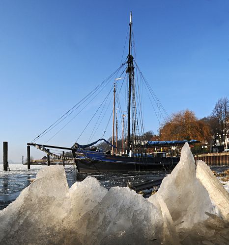 11_22736 Die Wintersonne scheint auf die Eisschollen im Museumshafen von Hamburg Oevellgoenne. Ein historisches Segelschiff liegt dort vor Anker. www.fotograf-hamburg.de  SAMMELSURIUM || Bilder vom Hamburger Winter