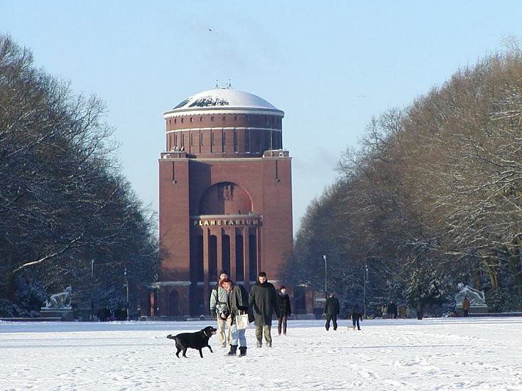 Hamburg im Winter - Blauer Himmel und Schnee im Stadtpark. Hamburg Fotografie der Jahreszeiten.  266_310016 Ein Hund spielt im Schnee mit seinem Ball - die Spaziergnger geniessen den blauen Himmel und die Sonne im Hamburger Stadtpark.