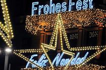 4656_1384 Leuchtschrift Frohes Fest - Feliz Navidad an einer Hausfassade. Beleuchtete Weihnachtssterne an den Zeltspitzen am Jungfernstieg.