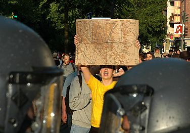 011_14235 - eine Anwohnerin steht vor der Polizeikette und hlt ein Plakat  "Nazis raus!" 