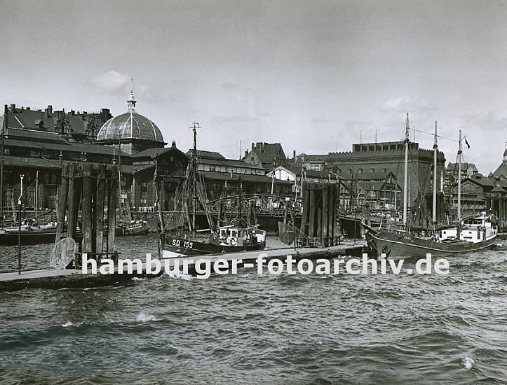 alte Fotos aus Hamburg Altona / St. Pauli - Fischkutter, Fischauktionshalle  33_47907 Fischkutter liegen am Anleger vor der Altonaer Fischauktionshalle - rechts das Khlhaus, in dem der Fang bis zum Weitertransport gekhlt wird. Dahinter verluft die Grenze von Altona und Hamburg; ganz rechts ist die Fischauktionshalle von Hamburg - St.  Pauli zu erkennen.   www.hamburger-fotoarchiv.de