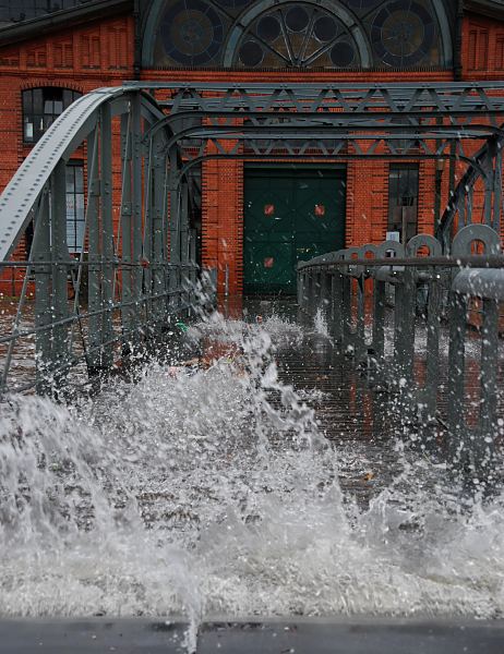 Hamburg Fotos vom Hochwasser Altona / St. Pauli  33_47909 Hochwasser in Hamburg; bei der Fischauktionshalle wird die Treppe zum Anleger Fischmarkt Altona bersplt. Die Gischt der Wellen spritzt zwischen den Holzbohlen der Wassertreppe hindurch. Im Hintergrund die Eingangstr zur Fischauktionshalle.   www.fotos-hamburg.de