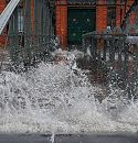 33_47909 Hochwasser in Hamburg; bei der Fischauktionshalle wird die Treppe zum Anleger Fischmarkt Altona überspült. Die Gischt der Wellen spritzt zwischen den Holzbohlen der Wassertreppe hindurch. Im Hintergrund die Eingangstür zur Fischauktionshalle.   ©www.fotos-hamburg.de