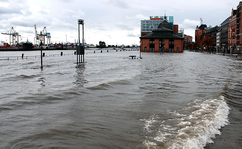 Bilder Sturmflut Hamburg - Hochwasser auf dem Fischmarktgelnde Altona / St. Pauli  33_47910 Das Hochwasser der Elbe hat die Kaimauer bersplt und das Gelnde des Hamburger Fischmarkts unter Wasser gesetzt. Auf der linken Bildmitte sind die Gelnder der Kaianlage zu erkennen, dahinter die Wassertreppe zum Anleger, die halb unter Wasser steht. Auch die Altonaer Fischauktionshalle steht im Wasser. Wellen auf der Grossen Elbstasse.  www.fotos-hamburg.de