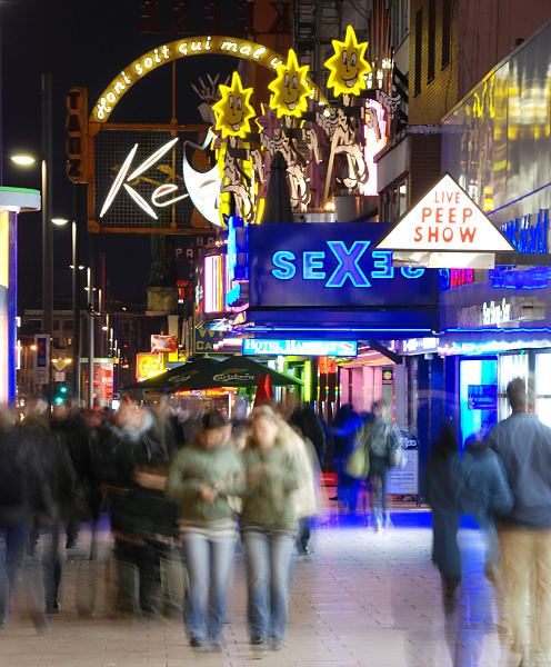 Fotos aus Hamburgs Bezirken // HH-Mitte, Stadtteil St. Pauli. Hamburgs Vergngungsviertel bei Nacht - Leuchtwerbung fr Peep Shows. Hamburger Fotografie Christoph U. Bellin.  34_41200 Auf der Reeperbahn drngen sich Nachts die Menschen auf dem Brgersteig - Touristen bummeln ber die Hamburger Sehenswrdigkeit, junge Menschen sind auf den Weg in die Disko oder einen der vielen Hamburger Musikclubs. Andere sind auf den Weg in eines der Theater die sich in dem Hamburger Vergngungsviertel befinden. Die Reeperbahn ist die zentrale Strasse St. Paulis. Hier finden sich neben Bars, Restaurants und Hotels auch Sexclubs und Theater. Die Strasse hat ihren Namen von den Seilmachern / Reepschlgern, die ihr Handwerk ab 1633 in dem Bereich der jetzigen Reeperbahn ausgebt haben.