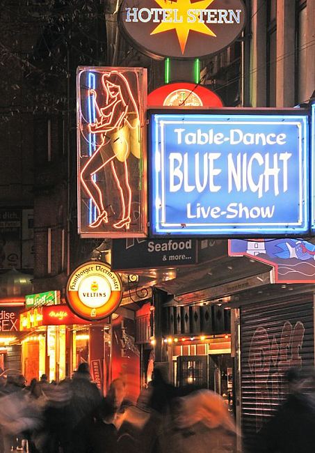 Fotos aus dem Bezirk Hamburg - Mitte; St. Pauli. Neowerbung auf der Reeperbahn. Leuchtschilder an Hausfassaden. 34_41209 Leuchtwerbung an den Husern an der Reeperbahn - Schilder machen Werbung fr den Blue Night Table-Dance, fr ein Hotel oder Biermarken auf Hamburg sndigster Meile im Rotlichtviertel.