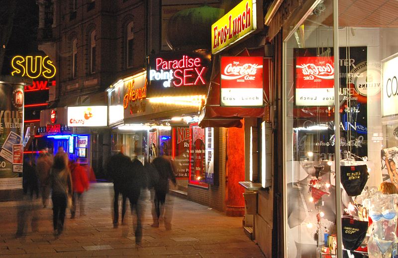 Fotografien aus den Hamburger Bezirken :: Hamburg Mitte, Stadtteil St. Pauli. Erleuchtete Geschfte auf der Reeperbahn. Schaufenster + Leuchtschriften.  34_41211 Passanten und Hamburg Touristen schlendern am Abend ber die Reeperbahn; Leuchtschilder machen werden fr den Eros-Lunch oder Point of Paradiese Sex.