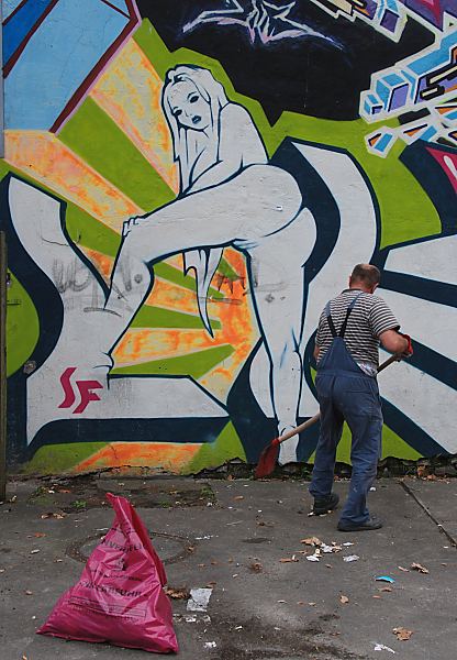 Bilder Hamburg St. Pauli / Kietz Reeperbahn  34-41213 Strassenreinigung auf Hamburgs sndiger Meile: die Reeperbahn in Hamburgs Stadtteil St. Pauli. Eine aufreizende, nackte Frau ist als Graffiti an die Hauswand gesprht,  ein Mann subert darunter die Strasse mit einer Schaufel, im Vordergrund ein gefllter Mllsack. www.fotos- hamburg.de