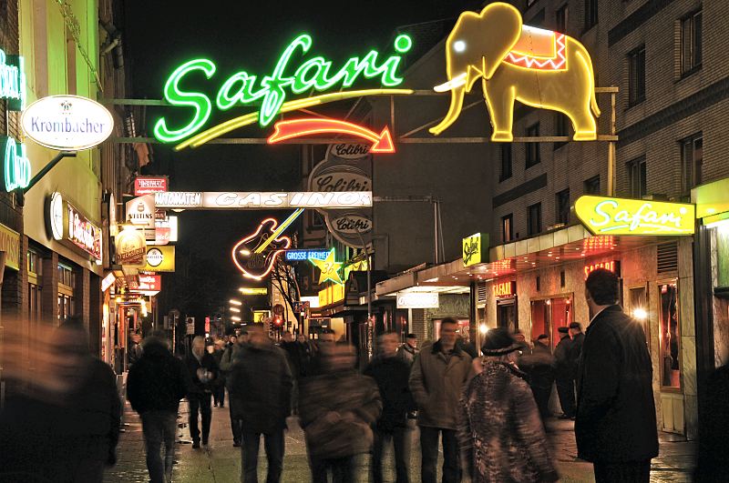 Hamburgbilder aus dem Bezirk Mitte; Stadtteil St. Pauli. Strae Groe Freiheit - Vergngungsviertel St. Pauli / Leuchtwerbung.  34_41220 Die Kiezbesucher und -besucherinnen bummeln durch die Groe Freiheit im Hamburger Rotlichtviertel - ber ihren Kpfen spannt sich die in grellen Farben leuchtende Neonwerbung der Kneipen, sowie Musik- und Sexclubs.