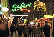 34_41220 Die Kiezbesucher und -besucherinnen bummeln durch die Groe Freiheit im Hamburger Rotlichtviertel - ber ihren Kpfen spannt sich die in grellen Farben leuchtende Neonwerbung der Kneipen, sowie Musik- und Sexclubs.