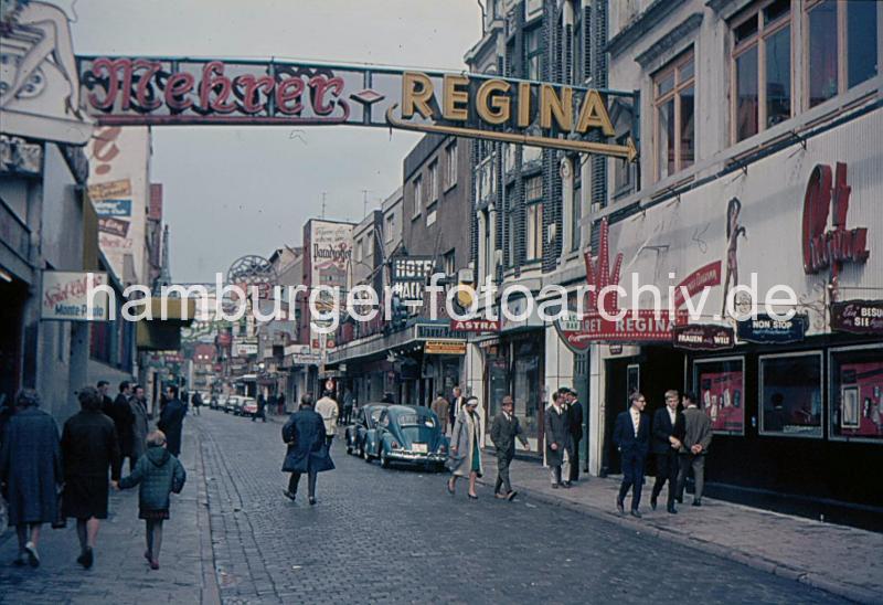 Bilder von Hamburg St. Pauli - Fotos Hamburger Stadtteile. Grosse Freiheit bei Tage - VW Kfer parken in der Strasse; ca. 1962.  35_41233 Dicht an dicht liegen die Nachtclubs und Hotels in der Groen Freiheit, eine der Nebenstrassen der Reeperbahn. Am Tag gehen Mtter mit ihren Kindern durch die Strasse - VW Kfer parken am Strassenrand.