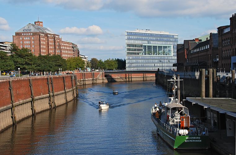 Hamburg Fotografien - Motorboote auf dem Zollkanal, Messberghof + Deichtor-Center   33_47951 Zwei Sportboote fahren auf dem Zollkanal; die Motorboote kommen vom Oberhafen und haben gerade den Wandrahmsteg passiert. Das ehem. Zollschiff Oldenburg liegt am Ponton des Deutschen Zollmuseums in der Hamburger Speicherstadt. Links hinter der Kaimauer die Strasse Dovenfleet, und der Messberghof, hinter der Brcke die moderne Architektur des Deichtorcenters.  www.fotograf-hamburg.de