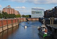 33_47951 Zwei Sportboote fahren auf dem Zollkanal; die Motorboote kommen vom Oberhafen und haben gerade den Wandrahmsteg passiert. Das ehem. Zollschiff Oldenburg liegt am Ponton des Deutschen Zollmuseums in der Hamburger Speicherstadt. Links hinter der Kaimauer die Strasse Dovenfleet, und der Messberghof, hinter der Brcke die moderne Architektur des Deichtorcenters.   www.fotograf-hamburg.de