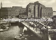 33_47953 Blick ber den Zollkanal ca. 1930 zum Messberg; Schlepper mit Kahn unter der Wandrahmbrcke, ein Lastwagen mit Anhnger fhrt ber die Brcke in den Hamburger Freihafen. Rechts der Messberghof und lks. das Chilehaus.; dahinter die Turmspitze der St. Jacobikirche.  www.hamburg-fotos.biz