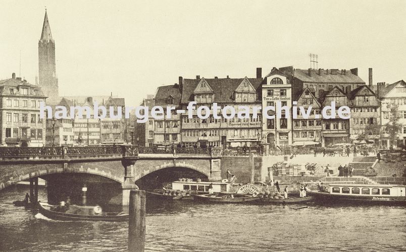 historische Hamburg Fotografien - Hamburger Zollkanal und Fachwerkhuser am Messberg  33_47989 Blick auf die Wandrahmbrcke und den Zollkanal; der Raddampfer MAIBLUME liegt am Kai und auch die Barkasse Tatenberg hat dort fest gemacht - davor mit Krben beladene Schuten. Links der Kirchturm der St. Jacobikirche hinter der historischen Architektur der Hamburger Altstadt. www.hamburg-bilder.biz