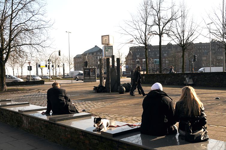 Fotos von Hamburg - Sonne an einem Winternachmittag am Messberg.  33_47992 Beim Messberg sitzen Hamburger in der Wintersonne auf dem mit Sitzbnken und einer Skulptur gestalteten Platz. Im Hintergrund Verkehr auf der ehemaligen Ost-West-Strasse und jetzigen Willy - Brandt - Strasse. Auf der anderen Seite der Hamburger Hauptverkehrsstrasse liegt der Wandrahmsteg und Gebude der Speicherstadt. www.fotograf-hamburg.de