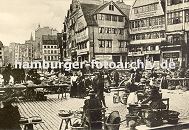 33_47997 Markt auf dem Hamburger Meberg; Marktfrauen haben ihre Marktstnde aufgebaut und verkaufen ihre Waren - leere Krbe sind gestapelt, eine Milchkarre wird mit den Milchkannen ber das Kopfsteinpflaster geschoben. Der Bauernmarkt auf dem Messberg war einer der grossen Marktpltze Hamburgs. Auf ihm verkauften die Erzeuger aus den Vierlanden und Marschlanden ihre Produkte wie Milch, Butter, Eier und Kse oder Kohl Gemse, Obst und Blumen. Im Hintergrund das Gelnder vom Klingbergfleet und Fachwerkhuser am Klingberg..www.hamburg-bilder.biz