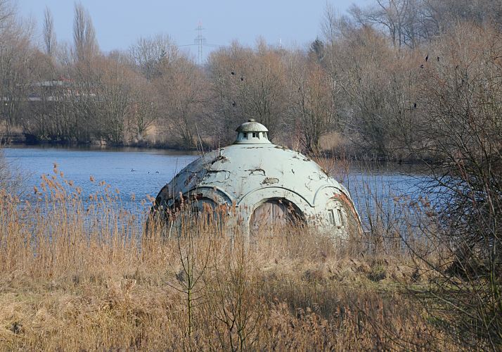 Hamburg Fotograf - Bilder vom Wasserwerk Billwerder Insel Kaltehofe, Pumpanlage  33_48017 Ablagerungsbecken auf der Billwerder Insel; bis 1964 wurde das Hamburger Trinkwasser u.a. bei Rothenburgsort aus der Elbe entnommen; in einem der ersten Reinigungsschritte wurde das Elbwasser in dem Ablagerungsbecken auf der Billwerder Insel von den groben Verunreinigungen gereinigt - diese sanken auf den Boden der Wasserbecken. Der kuppelfrmige Bau beinhaltet das Pumpwerk der Anlage. Nachdem die Nutzung der Wasserklranlage 1990 zur Gnze eingestellt wurde, hat sich auf dem eingezunten         44 ha groen Gelnde eine kologische Nische entwickelt. Wasservgel brten dort ungestrt, Krten und Frsche nutzen die Wasserbecken als Laichgebiet, auch Seeadler sollen auf Kaltehofe gesichtet worden sein.  Im Hintergrund sitzen Kormorane in den Bumen, die auf dem Gelnde eine Brutkolonie gebildet haben. www.fotograf-hamburg.com