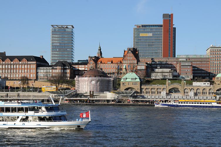 Hamburg - Fotos;  Bilder von den Hamburger Touristen-Attraktionen / Alter Elbtunne   33_48039 Das kupfergedeckte Kuppelgebude vom Eingang des Alten Elbtunnels wird noch restauriert und ist teilweise mit Planen geschtzt. Ein Fahrgastschiff der Hamburger Hafenrundfahrt fhrt mit seinen Fahrgsten und Touristen an Bord auf der Elbe vor den St. Pauli Landungsbrcken Richtung Hafencity; die Hamburger Flagge weht am Bug des Schiffs. Der St. Pauli Elbtunnel wurde 1911 erffnet - ca. 4400 Arbeitskrfte arbeiteten fast vier Jahre an den beiden 426m langen Tunnelrhren. Auf zwei Fahrbahnen knnen Fussgnger und PKW die Elbe in 24m Tiefe unterqueren - Fahrsthle transportieren die Autos und Menschen hinunter. Hinter der Kuppel des Elbtunnels liegt das historische Gebude der Navigationsschule und auf der linken Seite die Schumacher-Architektur vom Tropeninstitut. www.bilder-hamburg.de