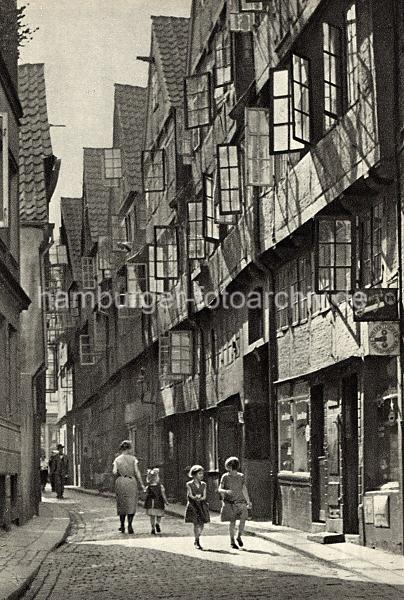 Historische Fotos vom Hamburger Gngeviertel. Fachwerkhuser und Kinder im Rademachergang. 03_076 Als Gngeviertel wurden die besonders eng bebauten Wohnquartiere in einigen Teilen der Hamburger Altstadt und Neustadtbezeichnet. Die Gngeviertel waren grtenteils mit Fachwerkhusern bebaut, deren Wohnungen zumeist nur durch schmale Straen und ber Hinterhfe und den Gngen zwischen den Husern zu erreichen waren.  In den Gnge- vierteln wohnten meist mittlere und rmere Bevlkerungs- schichten; aufgrund der schlechten hygienischen Zustnde, aber auch aus sozialen und politischen Bestrebungen begannen bereits zum Ende des 19. Jahrhunderts die ersten Sanierungsmanahmen durch Abriss.