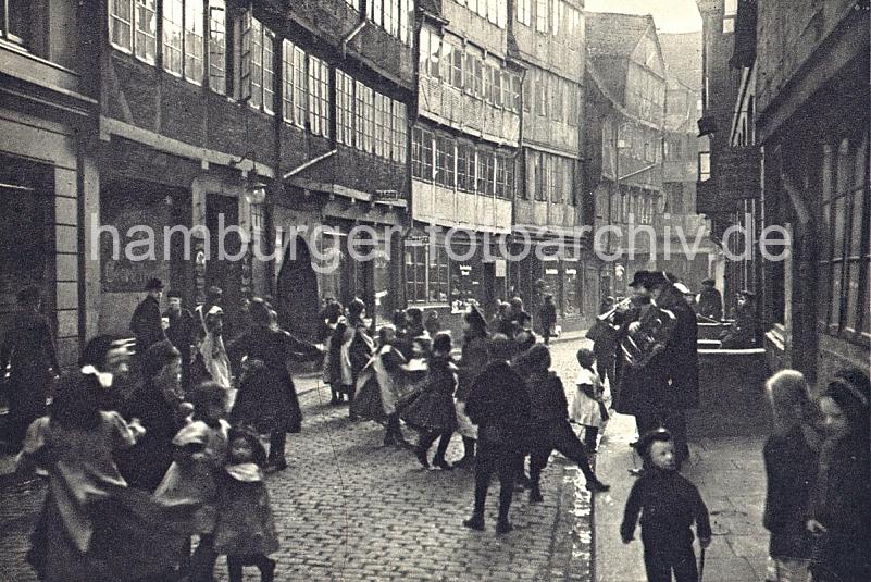 Historische Bilder aus der Hansestadt Hamburg - Fachwerk Architektur im Gngeviertel. Kinder tanzen auf dem Kopfsteinpflaster zu der Musik ein typischen Hamburger Pankoken Kapelle. 05_127_14 Als Gngeviertel wurden die besonders eng bebauten Wohnquartiere in einigen Teilen der Hamburger Altstadt und Neustadtbezeichnet. Die Gngeviertel waren grtenteils mit Fachwerkhusern bebaut, deren Wohnungen zumeist nur durch schmale Straen und ber Hinterhfe und den Gngen zwischen den Husern zu erreichen waren.  In den Gngevierteln wohnten meist mittlere und rmere Bevlkerungsschichten; aufgrund der schlechten hygienischen Zustnde, aber auch aus sozialen und politischen Bestrebungen begannen bereits zum Ende des 19. Jahrhunderts die ersten Sanierungsmanahmen durch Abriss.