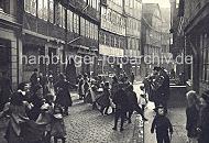 Historische Bilder aus der Hansestadt Hamburg - Fachwerk Architektur im Gngeviertel. Kinder tanzen auf dem Kopfsteinpflaster zu der Musik ein typischen Hamburger Pankoken Kapelle. 