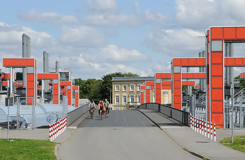 Fotografien aus Hamburg Rothenburgsort. Sperrwerk Billwerder Bucht Rothenburgsort - Radfahrer berqueren die Wasserschutzanlage / Hamburg-Fotograf Christoph Bellin.  1439_3594 Das 145m lange Sperrwerk an der Billwerder Bucht zur Elbe wurde 2003 erneuert und auf eine neue Schutzhhe von +8,20 m erhht. Das Sperrwerk hat 4 ffnungen von 2x30m und 2x34,5 m. Vorher bot es einen Schutz gegen Sturmflutwasserstnde von ca. +7 m. Die Hochwasserschutzanlage schtzt die Billwerder Bucht, die Ende des 19. Jh. aus einem abgeschnittenen Altarm der Norderelbe sdlich von Rothenburgsort entstand. Heute dient die Billwerder Bucht als kologisch wertvolles tideoffenes Gewsser mit einer Wasserflche von rd. 170 ha vorwiegend als Binnenschiffs- und Sportboothafen. Das Sperrwerk liegt auf der beliebten Fahrradroute entlang der Norderelbe nach Tatenberg und zur Doveelbe. Eine Gruppe RadfahrerInnen berquert die Hochwasserschutzanlage.