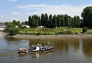 1455_3913 Ein Sportboot kommt aus der Richtung Billehafen und fhrt am Elbpark Entenwerder vorbei in die Norderelbe. Die Passagiere des Motorboots sitzen am Heck des Schiffs in der Sonne. 