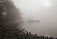 1458_1750 Ein nebliger Herbstmorgen im Oktober am Ufer der Elbe - bei Ebbe kommt Uferbefestigung beim Elbpark Entenwerder zum Vorschein. Im Hintergrund im Nebelschleier Arbeitsboote am Anleger Entenwerder. 