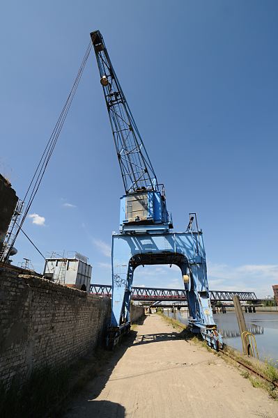 Hamburg Fotograf. Fotografien aus dem Hamburger Stadtteil Rothenburgsort - Hafenkran im Billhafen - Hafenkai.  1463_3874 Der blaue Hafenkran am Billhafen in Hamburg Rothenburgsort wird auf Schienen entlang der Kaianlage bewegt. Im Hintergrund die Eisenbahnbrcke ber den Oberhafenkanal.