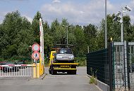 1482_3684 In Hamburg Rothenburgsort befindet sich in der Ausschlger Alle, in der Nhe der S-Bahnstation Tiefstack Hamburgs Zentraler Autoverwahrplatz. Dort werden die wg. Falschparkens abgeschleppten Fahrzeuge abgestellt und gegen eine Gebhr von ca. 250 EUR wirder an den/die FahrzeughalterIn zurckgegeben.  Ein Abschleppwagen fhrt durch die geffnete Schranke mit einem abgeschleppten Wagen auf der Ladeflche auf das Gelnde des Verwahrplatzes Videokameras berwachen die Anlage - nachts ist der durchgehend geffnete Platz mit einer Flutlichtanlage beleuchtet.