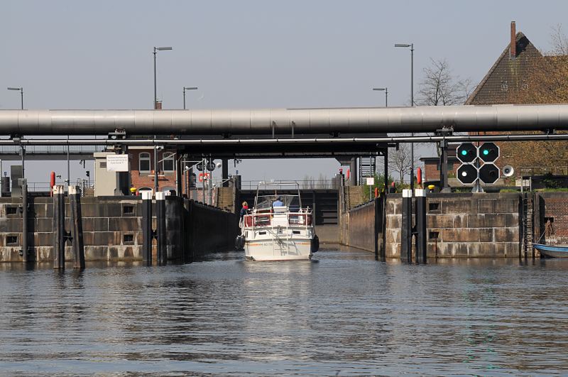 Bilder aus dem Hamburger Bezirk Hamburg; Stadtteil Rothenburgsort.Ein Motorboot fhrt in die Tideschleuse Tiefstack ein.  1495_6032  Das Schleusentor ist geffnet, das grne Signallicht an der Tideschleuse gewhrt die Einfahrt fr das Sportboot, das aus dem Tiefstackkanal kommt. Die Schleuse am Tiefstack bringt das Boot auf den Wasserstand der Elbe, der tidenabhngig schwankt.