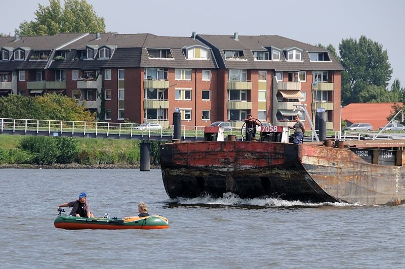 Bilder aus Hamburg Stadtteil Rothenburgsort - Bezirk HH-Mitte. Schubleichter und Schlauchboot mit Aussenbordmotor in der Billwerder Bucht. 1502_4780  Ein Schubleichter wird von einem Schubschiff ber die Billwerder Bucht gefahren; zwei Schiffer stehen am Bug des Schiffs und beobachten das kleine Schlauchboot, das sich anscheinend auf ihrer Route befindet.