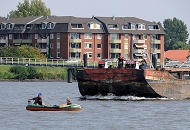 1502_4780  Ein Schubleichter wird von einem Schubschiff ber die Billwerder Bucht gefahren; zwei Schiffer stehen am Bug des Schiffs und beobachten das kleine Schlauchboot, das sich anscheinend auf ihrer Route befindet.