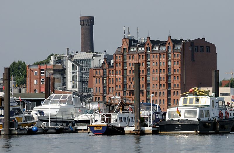 Fotos aus Hamburg - Bezirk Hamburg-Mitte - Stadtteil Rothenburgsort. Motorboote und Barkassen in einem Yachthafen der Billwerder Bucht. 1504_4760  Sportboote und Barkassen liegen am Ponton einer Hafenanlage in der Billwerder Bucht. Im Hintergrund das historische Speichergebude am Ausschlger Elbdeich, dahinter ragt der Turm der Wasserwerke Rothenburgsort empor.