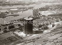 1508_1133  Luftfoto vom das Gasometer der Gaswerke Billwerder Ausschlag ca. 1931 - im Vordergrund die Gleise des Rangierbahnhofs Rothenburgsort; rechts oben der Wasserturm der Wasserkunst Rothenburgsort und auf der linken Bildseite Wasserbecken / Filterbecken der Elbinsel Kaltehofe. In der Billwerder Bucht liegen die Binnenschiffe, die die Kohle fr das Kraftwerk Tiefstack oder das Gaswerk zur Energiegewinnung angeliefert haben. Auf der anderen Seite der Norderelbe sind Gebude auf der Peute zu erkennen; rechts der Peute-Hafen und die Einfahrt des Peute Kanals. 